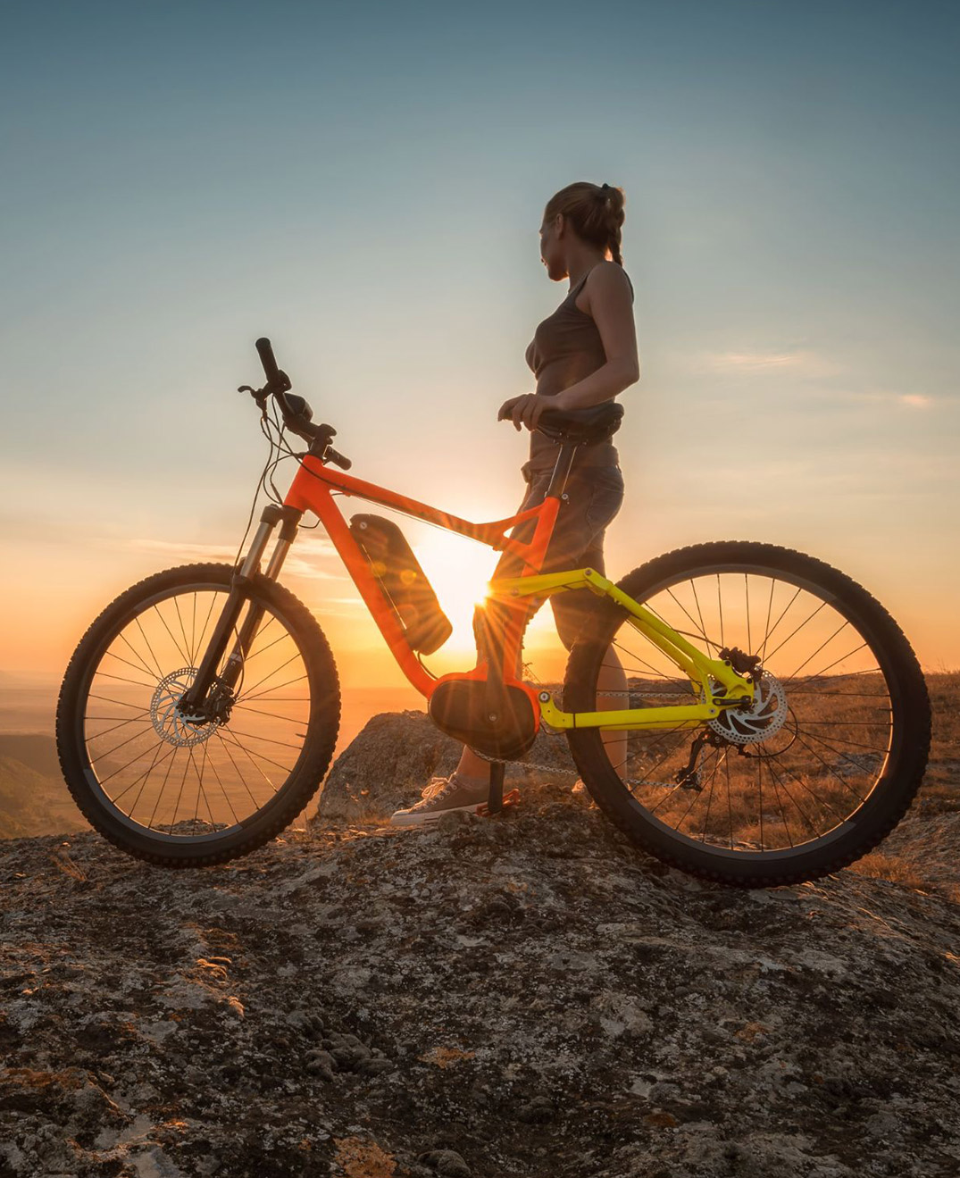 Frau mit E-Bike im Abendlicht