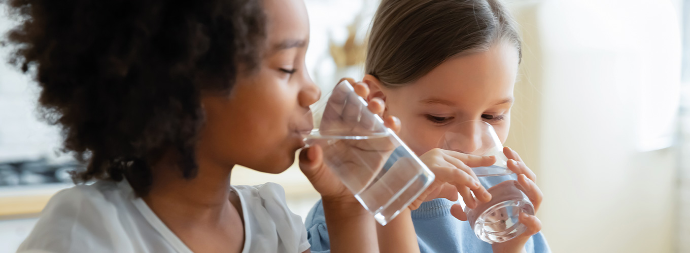 Kinder trinken ein Glas Wasser